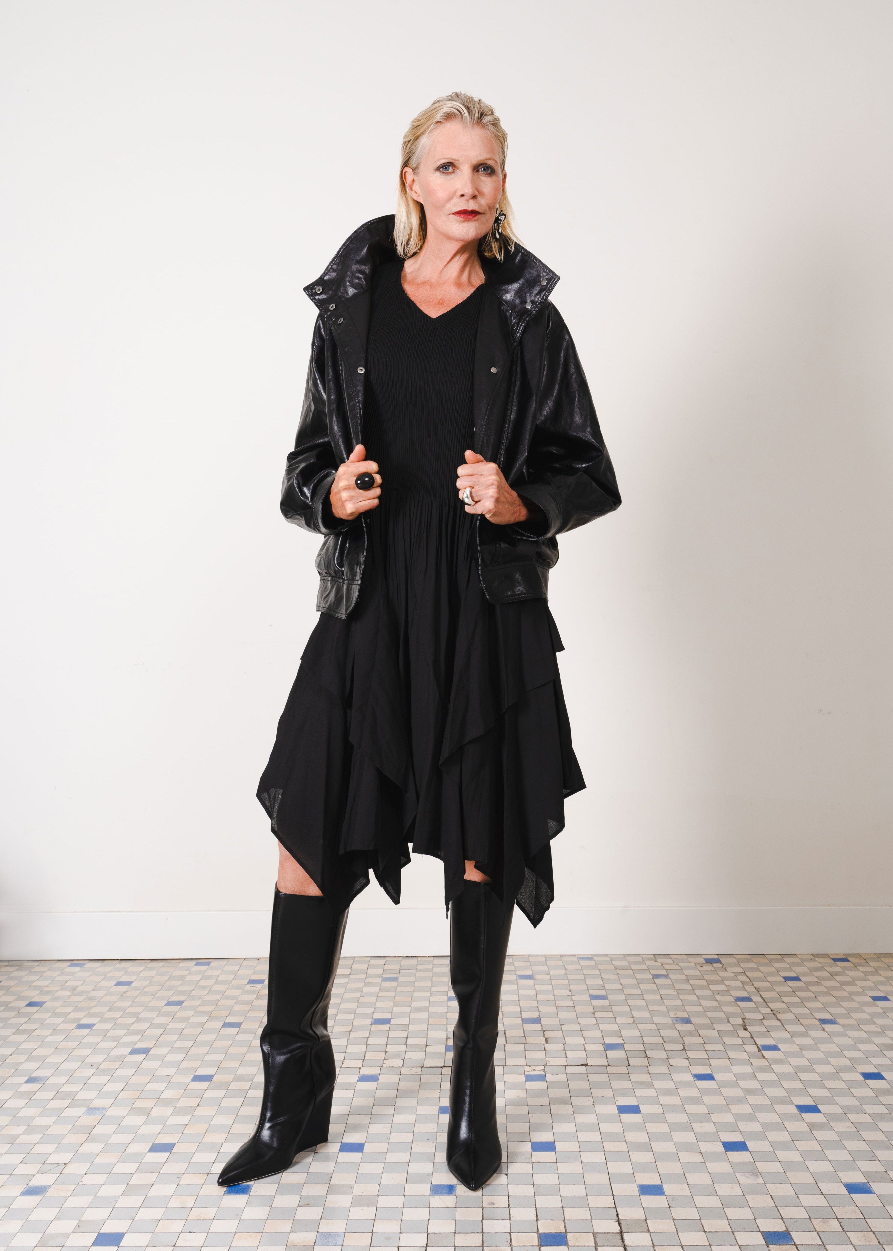 Woman wearing a black outfit with a hooded jacket on a white background